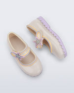 Side and top view of a pair of beige Hip Ballerina Star baby Mary Jane shoes with lavender soles and star-shaped straps