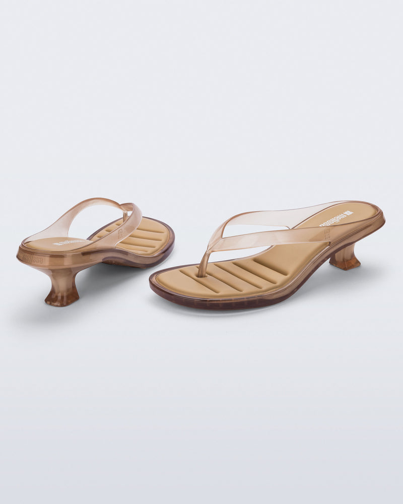 Back and angled view of a pair of clear beige Flip Flop Kitten Heels