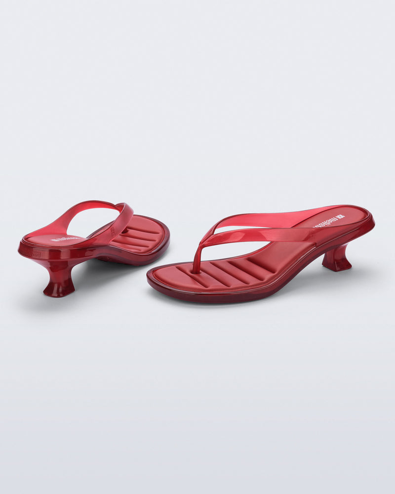 Back and angled view of a pair of transparent red Flip Flop Kitten Heels