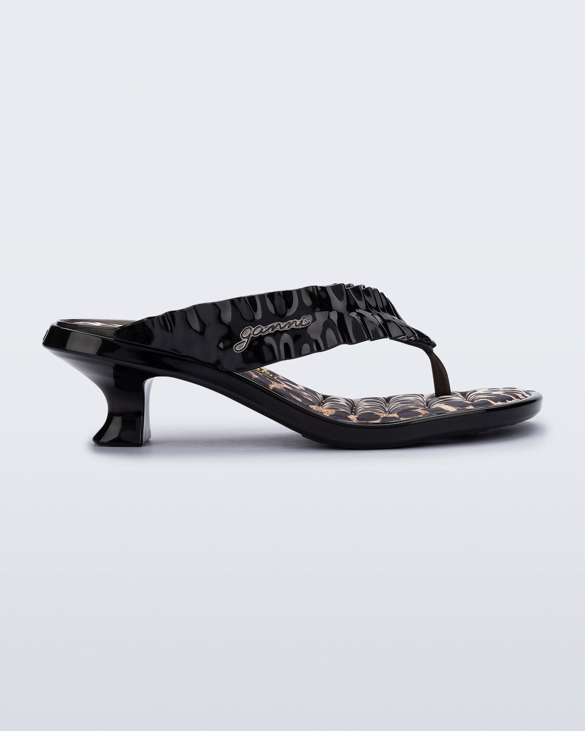 side view of a black Flip Flop Kitten Heel + GANNI sandal with leopard print foot bed and faux ruffle strap
