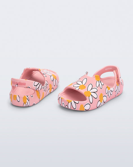 Back and angled view of a pair of pink Free Cute baby sandals with daisy print