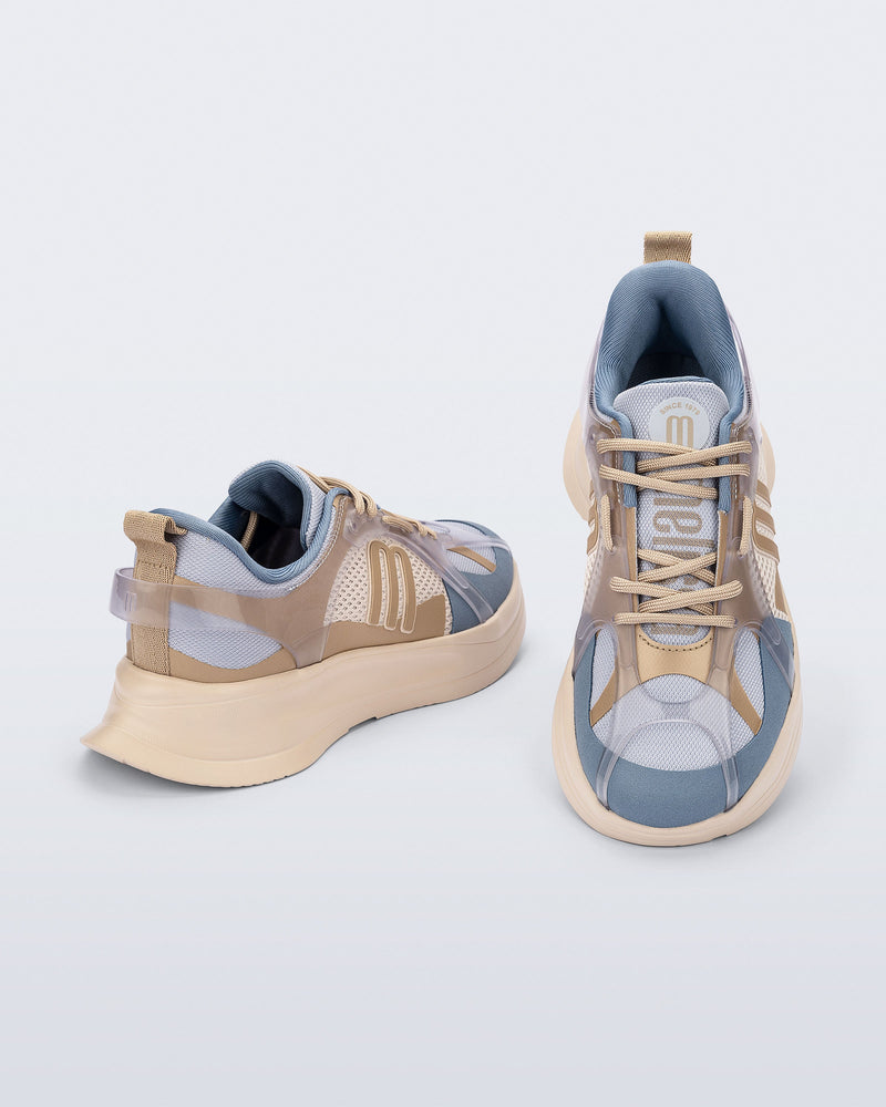 Top and back angled view of a pair of beige and gray Melissa X sneakers on a light gray background