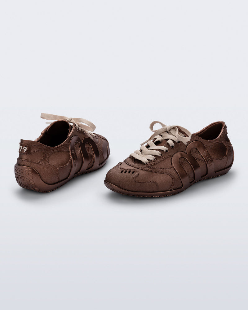 Back and angled view of a pair of bronze Motion sneakers with beige laces