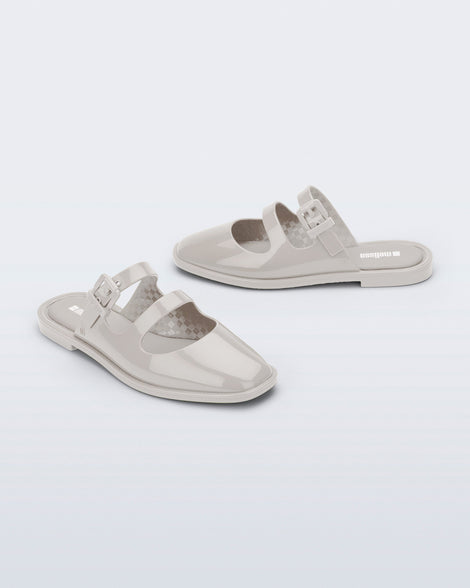 Side and angled view of a pair of beige Anastasia mule slides