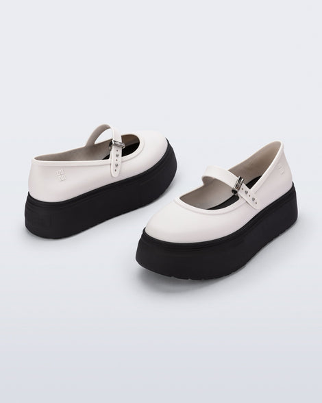 Back and side angled view of a pair of white Soft Ballerina Platform flats with black soles