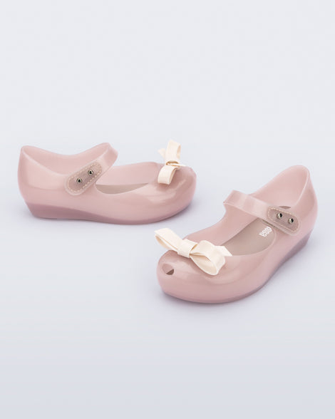 Angled view of a pair of pink baby Ultragirl Bow flat