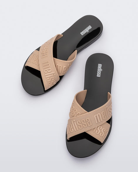 Top view of a pair of beige M Lover adult slides with black sole
