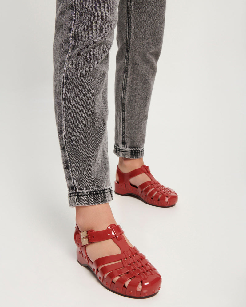 Model's legs wearing a pair of red Possession Pescura + Scholl fisherman sandals