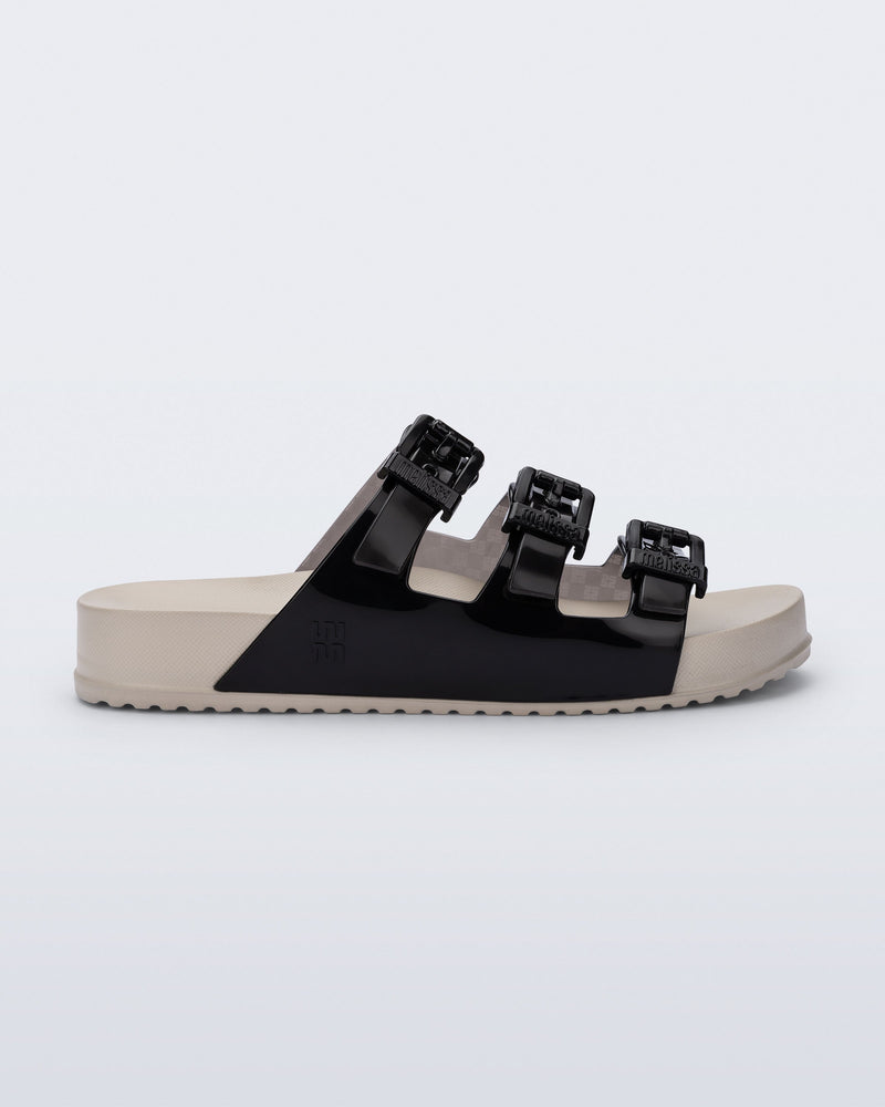 Side view of a beige Cozy Stripes sandal with black upper with 3 buckles