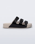 Side view of a beige Cozy Stripes sandal with black upper with 3 buckles