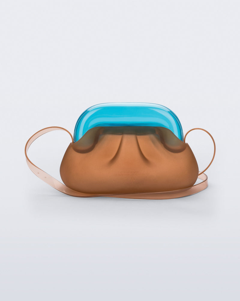 Back view of a small clear orange bag with blue clutch and long strap