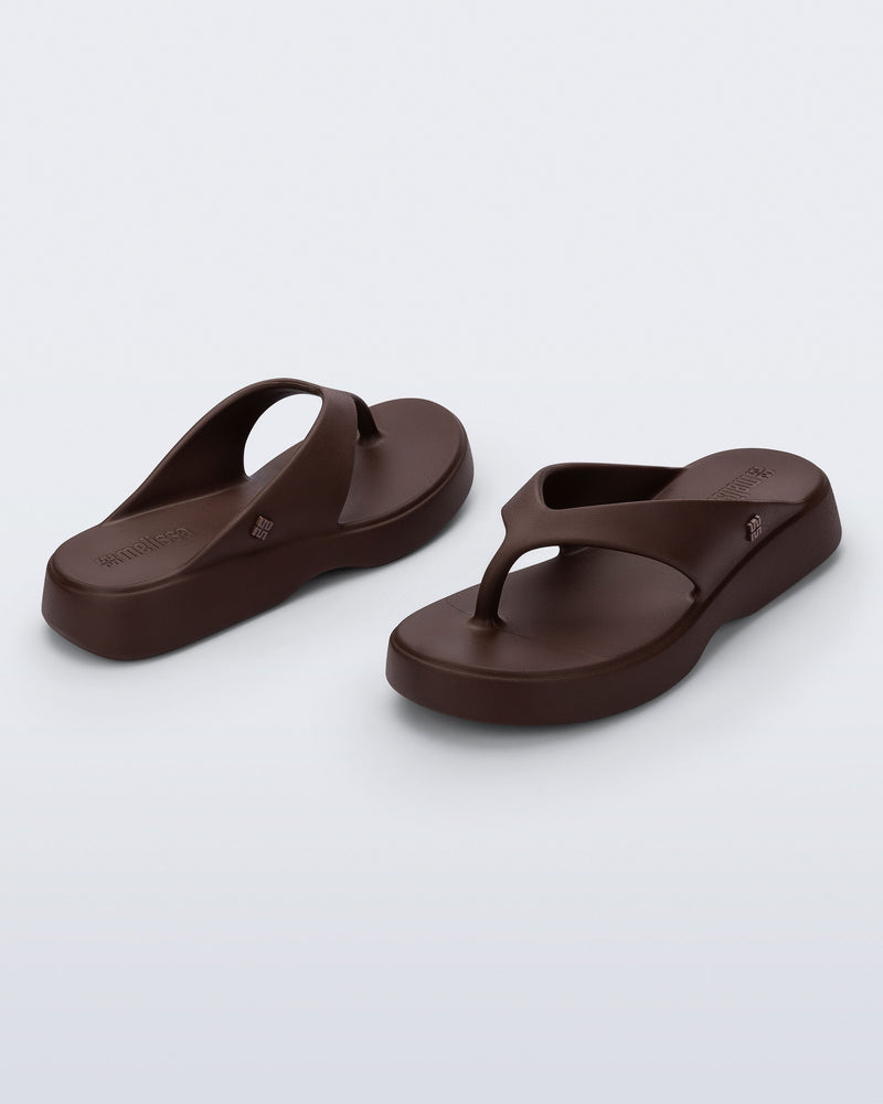Angled view of a pair of bronze Free Thong Low Flip Flops