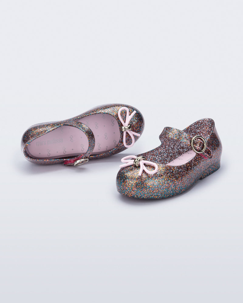 Top and angled view of a pair of glitter clear pink baby Sweet Love flats