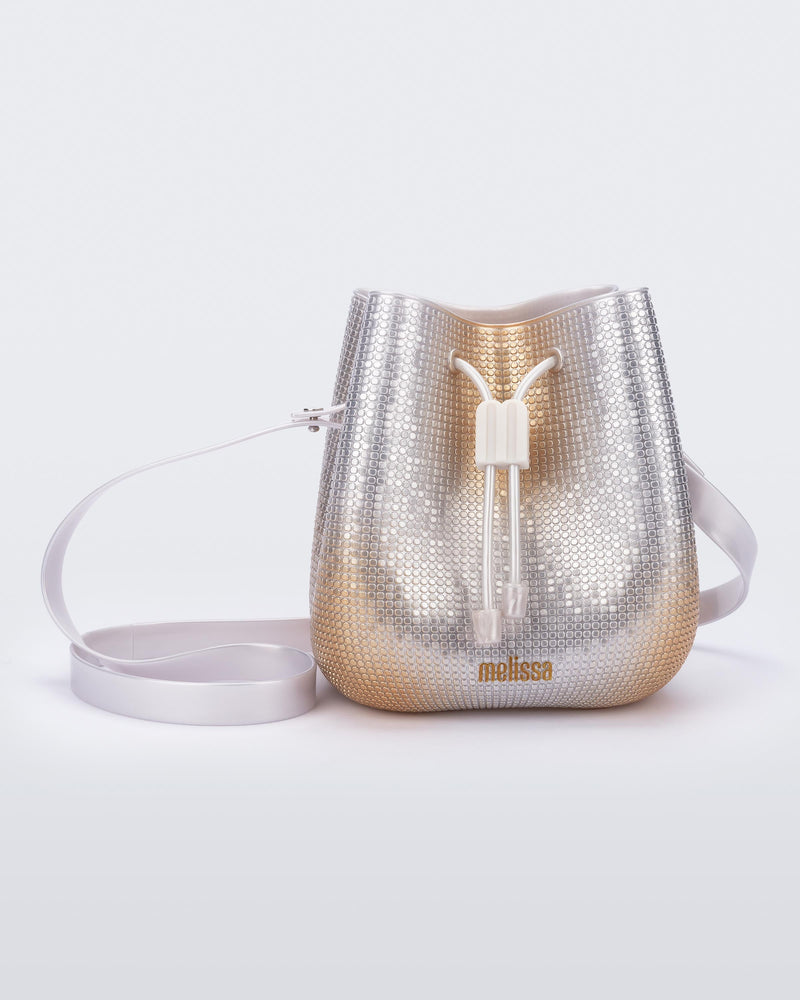 Front view of a silver/gold Lux bucket bag with drawstring and strap