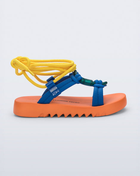 Side view of an orange sole, blue upper, and yellow ankle strap Kirk + Alexandre Pavao sandal