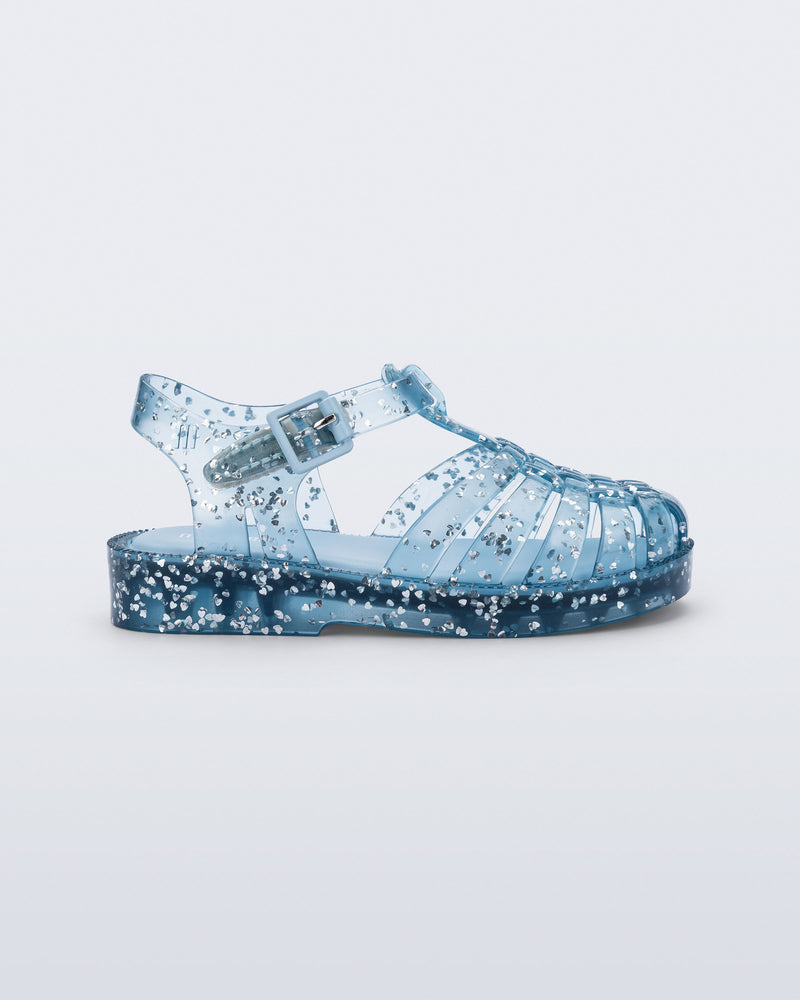 Side view of a blue Possession Elements baby sandal with glitter hearts