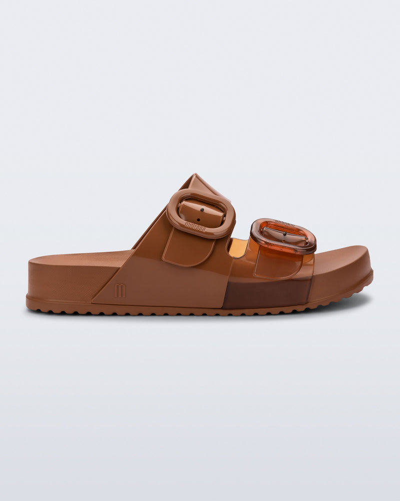 Side view of a brown Cozy slide with part clear brown upper with 2 buckles