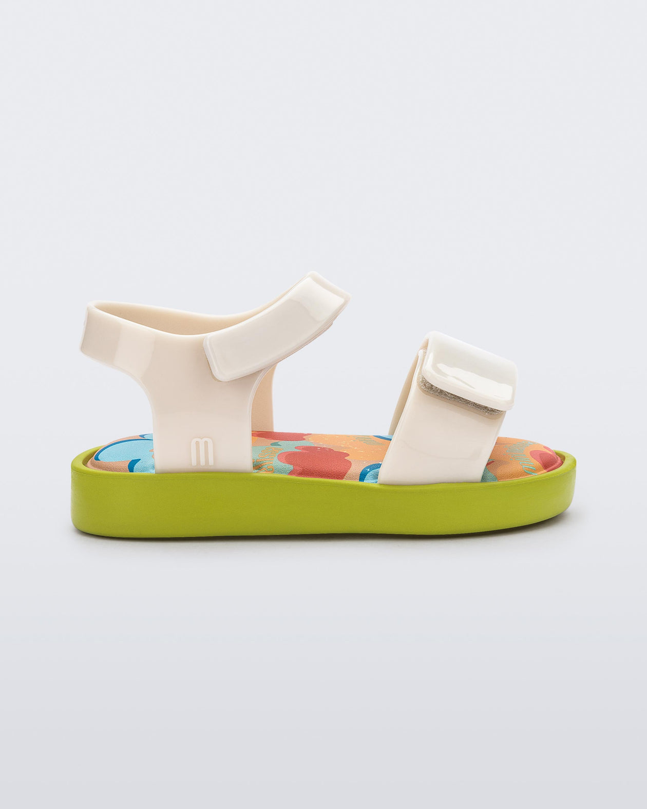 Side view of a beige baby Jump sandal with green sole