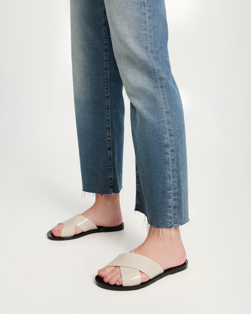 Models legs wearing a pair of black Essential Cross Slide sandals with beige colored straps