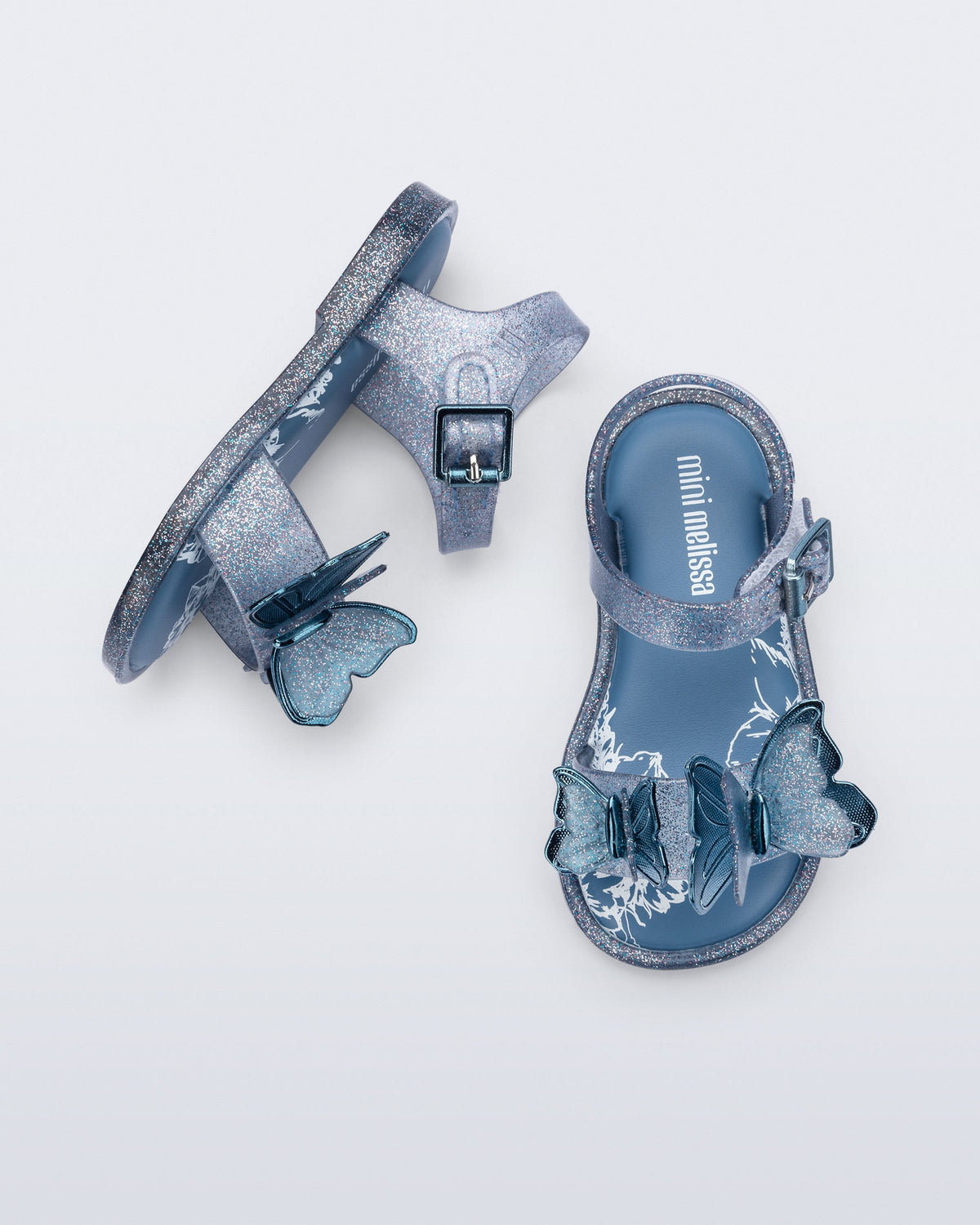 Top and side view of a pair of glitter blue baby Butterfly sandals with blue butterflies