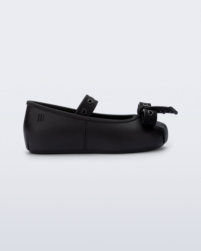 Side view of a black Sophie Crush baby ballerina flat with bow