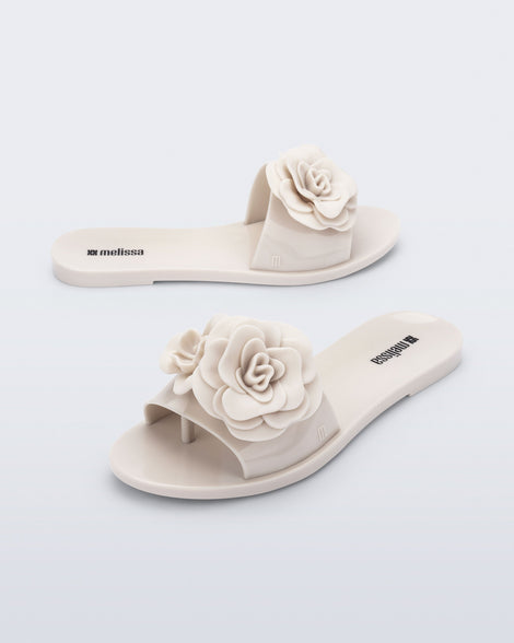 Side and angled view of a pair of beige Babe Petals slide sandals