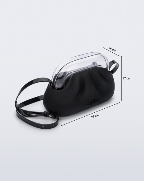 Angled view of a small black bag with clear clutch and long strap with measurements 27 cm x14 cm x 17 cm