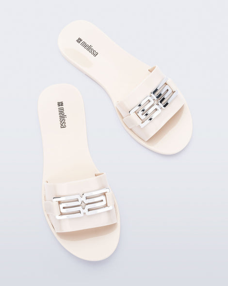 Top view of a pair of beige Babe M Chic slide sandals
