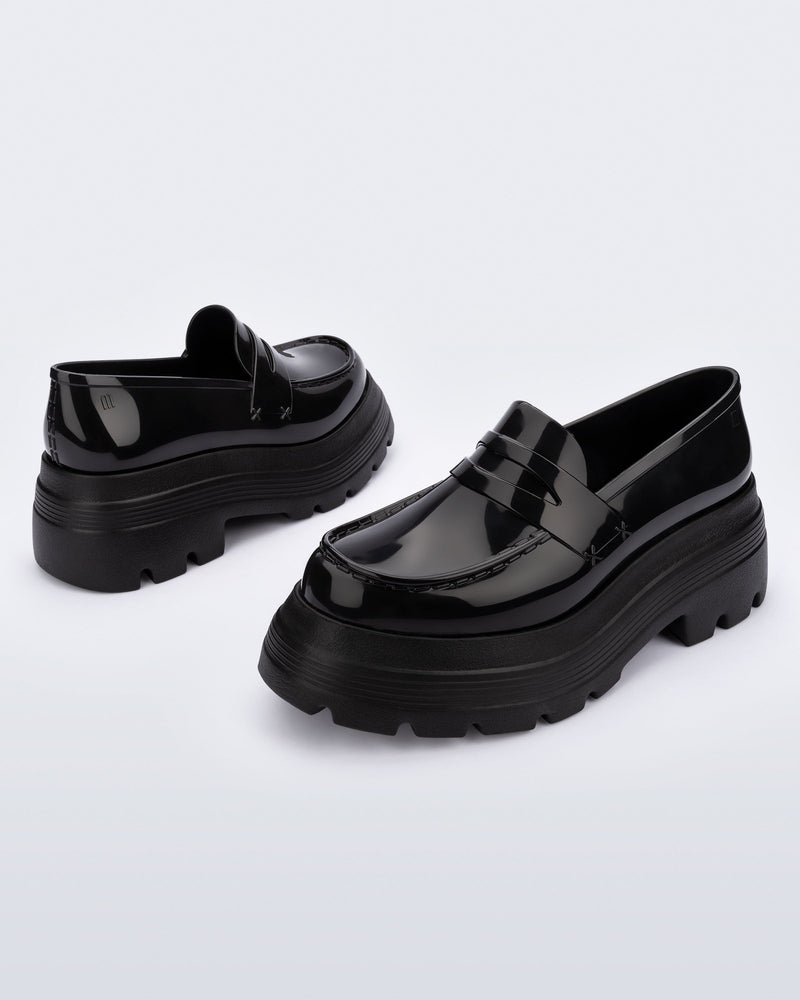 Angled view of a pair of black Royal High + Undercover platform loafers.