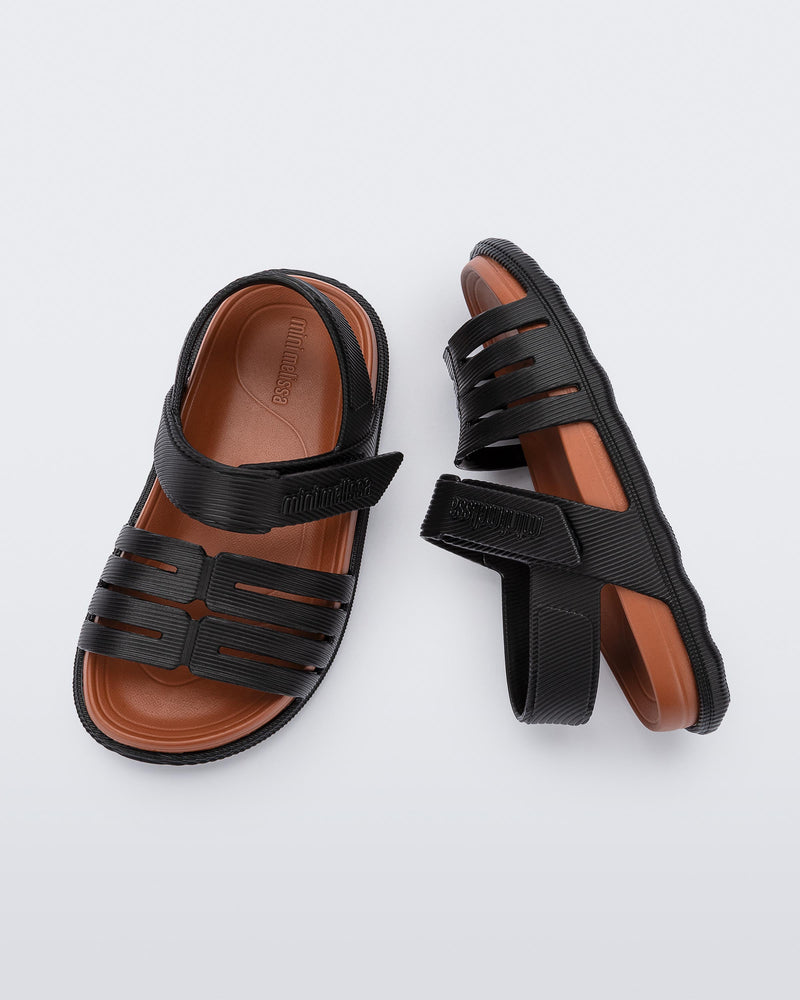 Top and side view of a pair of black with brown insole Kaiteki baby sandals