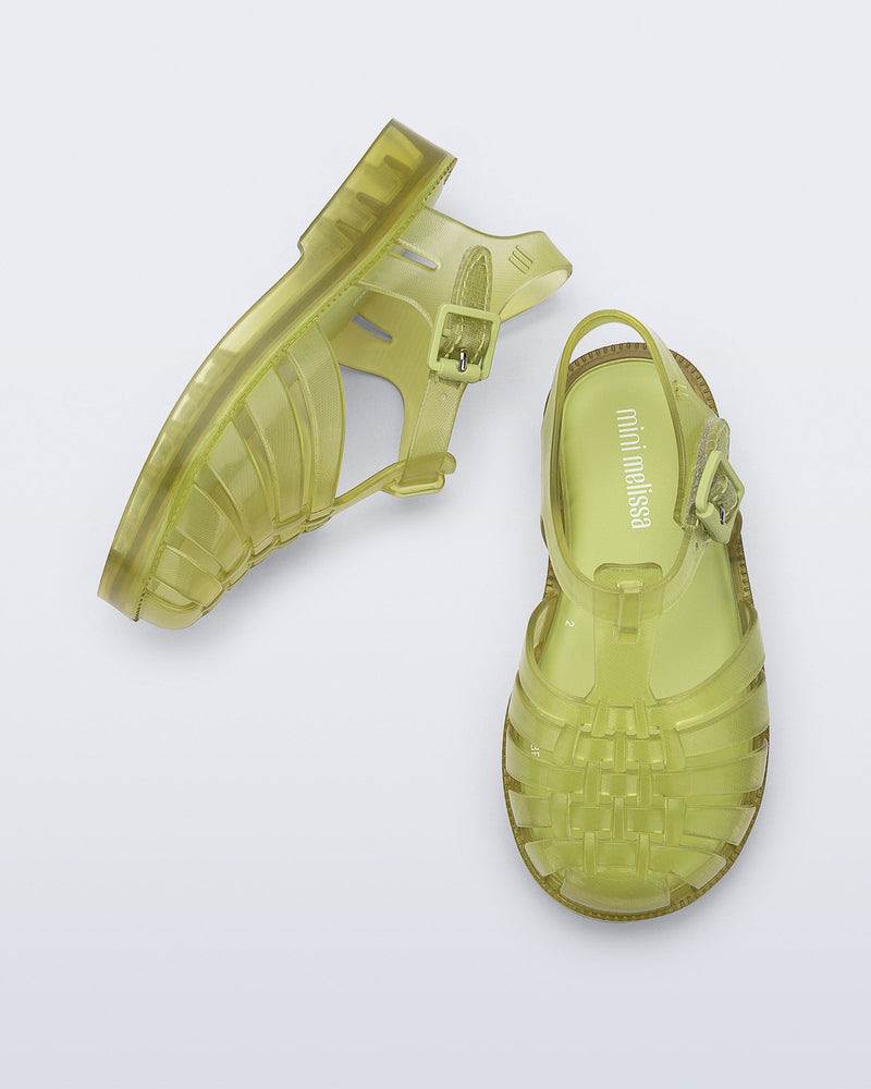 Top and side view of a pair of transparent green Possession fisherman baby sandals