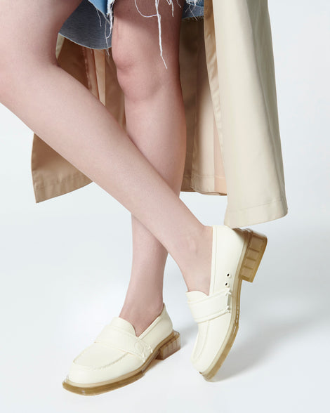 Model's legs in jean shorts wearing a pair of beige Spencer loafers with clear beige soles
