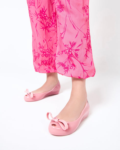 Model's legs in pink pants wearing a pair of black Ultragirl Bow flats