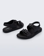 Side and angled view of a pair of black Wave Sandals with two straps with buckles and a back strap