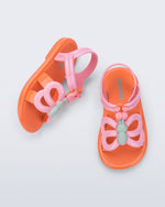 Side and angled view of a pair of pink strap, orange sole Hip Butterfly baby sandals