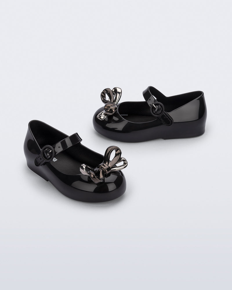 Angled and side view of a pair of black Sweet Love Glam baby ballerinas with bow
