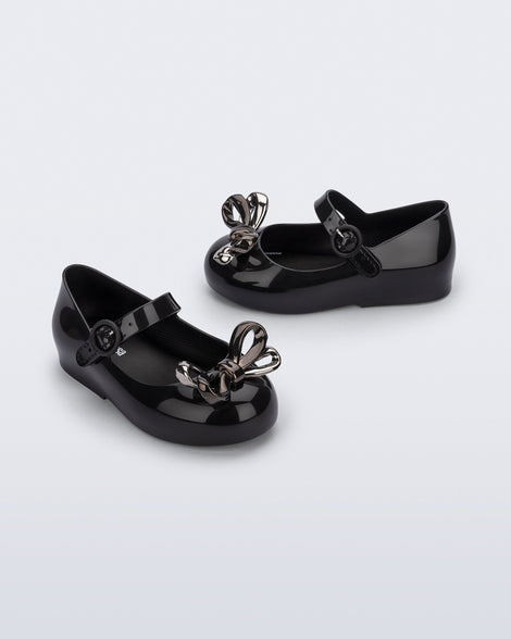 Angled and side view of a pair of black Sweet Love Glam baby ballerinas with bow