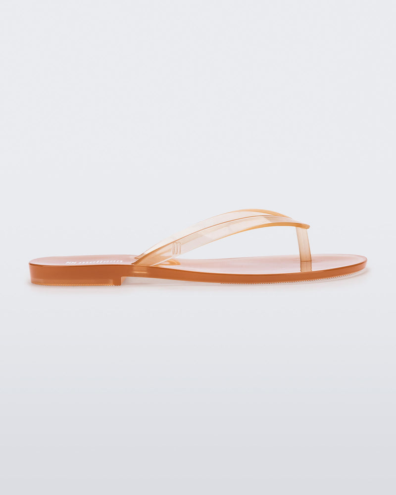 Side view of a clear beige Harmonic Jelly flip flop