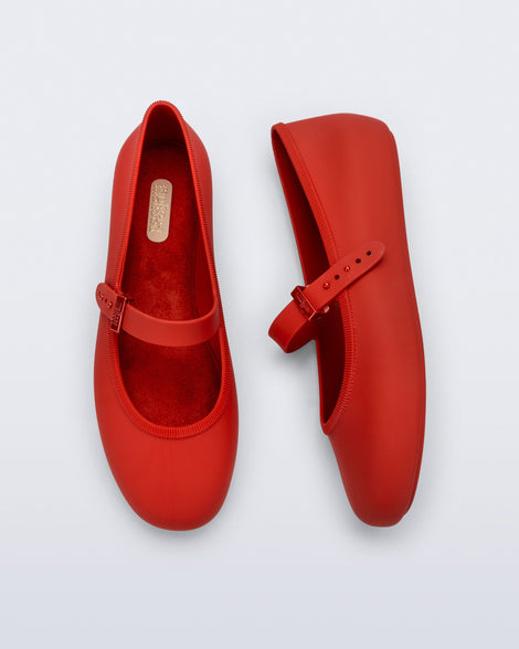Side and top view of a pair of red Soft Ballerina flats with top buckle strap