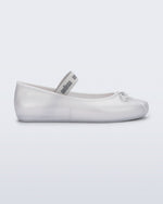 Side view of a pearly white Sophie flat with top elastic strap and small bow