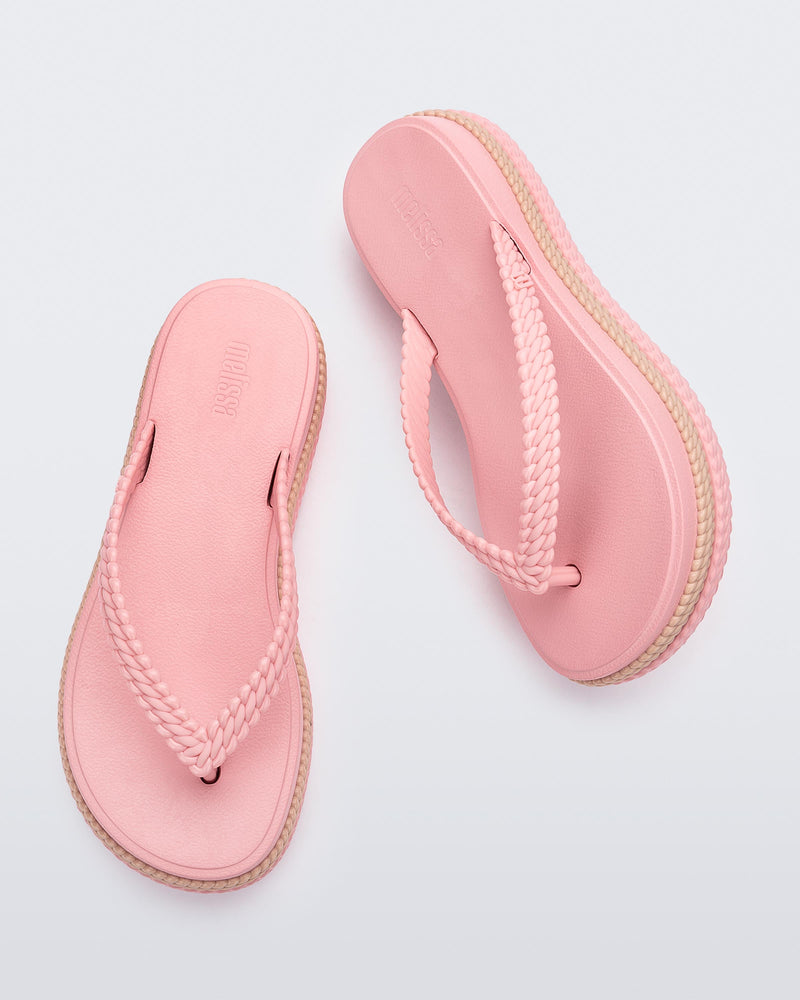 Top view of a pair of pink/beige Melissa Leblon platform flip flops with details that mimic sisal braids on the sole and strap