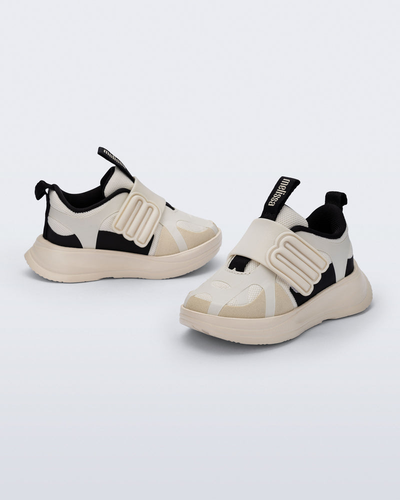Side and angled view of a pair of off white X Beat baby sneakers with black trim