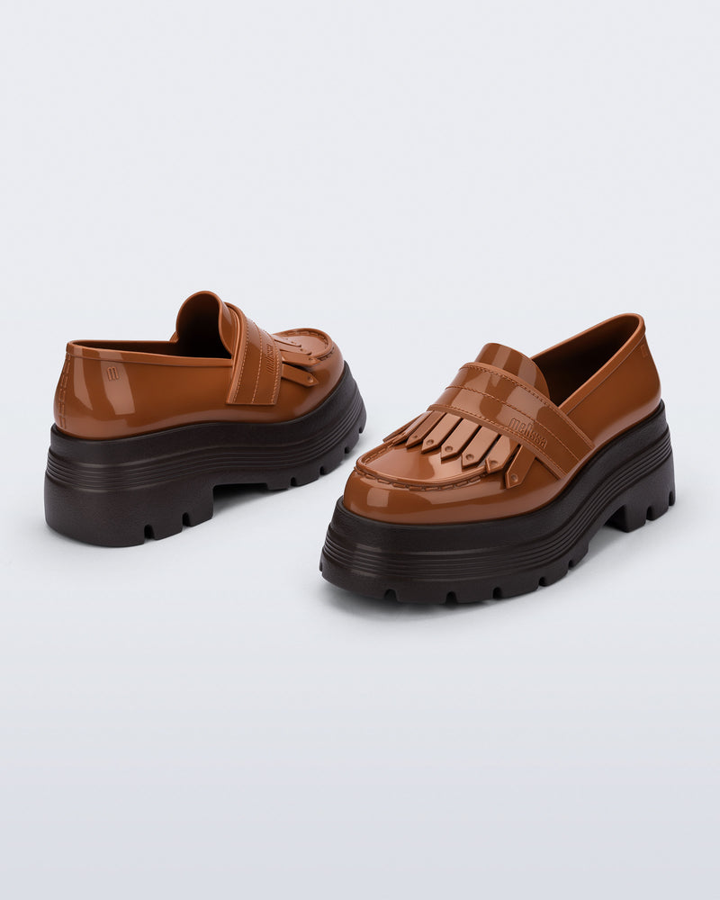 Back and angled view of a pair of brown Royal Plus Platform loafers with black sole