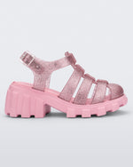 Side view of a glitter pink Megan kids heel sandal.