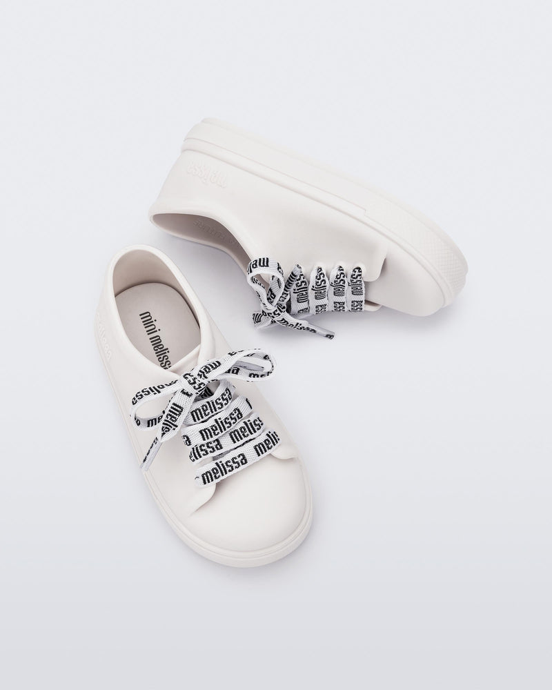 Angled view of a pair of white baby Hip M Lover sneakers with laces