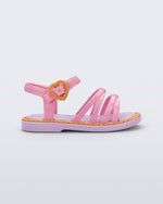 Side view of a pink Aurora baby sandal with purple sole and orange trim and buckle