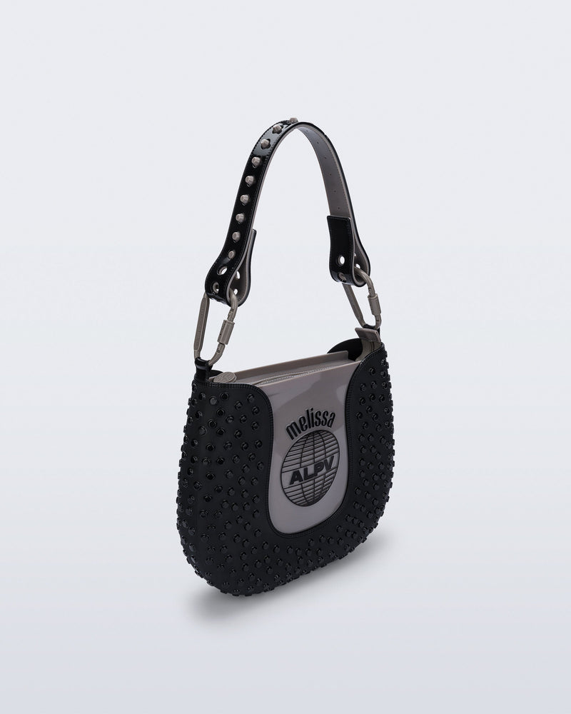 Angled view of a black Nina Bag + Alexandre Pavao shoulder bag with grey accents