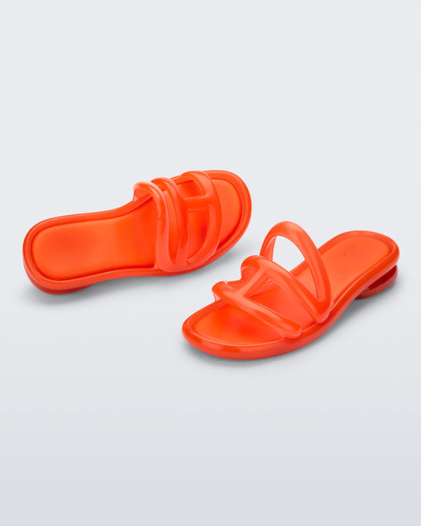 Angled view of a pair of orange Jelly Slide x Telfar.