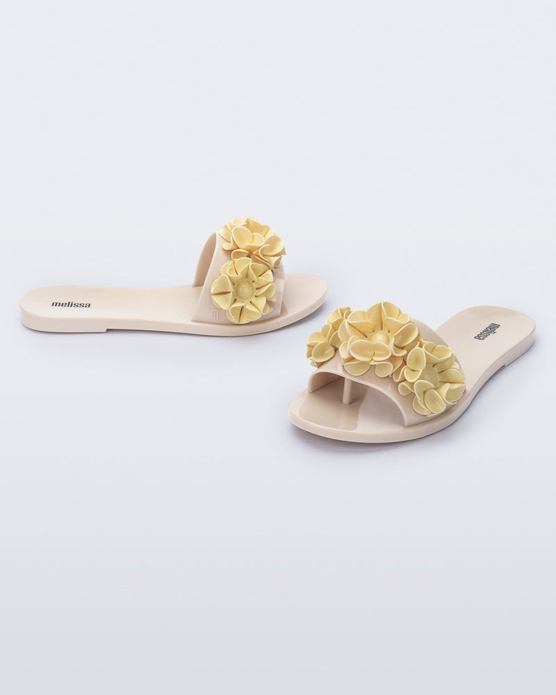 Angled view of a pair of beige Babe Springtime slides.