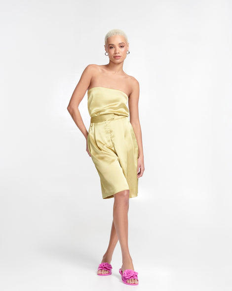 Model in a gold dress wearing a pair of pink Babe Petals slide sandals